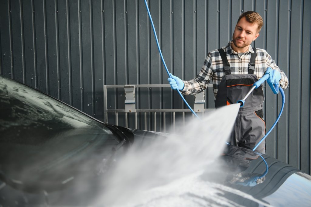 Car Wash Specialist Using Pressure Washer to Rinse a car
